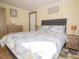 A bedroom with a bed, bedside table, and dresser at Lower Brambleside in Truro