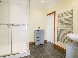 A bathroom with a shower, sink, and towel rail at Lower Brambleside in Truro