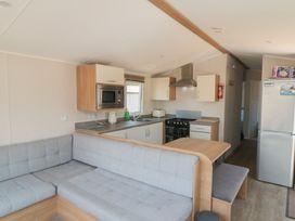 A kitchen with a stove and refrigerator at 14 Pines, Cayton Bay