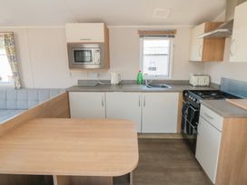 A kitchen with a microwave and stove at 14 Pines, Cayton Bay