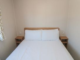 A bedroom with a bed and bedside tables at 14 Pines in Cayton Bay