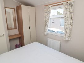 A bedroom with a bed, wardrobe, and window at 14 Pines Cayton Bay