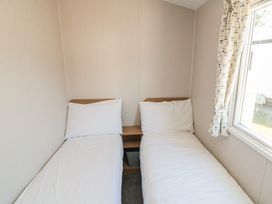 A bedroom with two beds and a window at 14 Pines in Cayton Bay