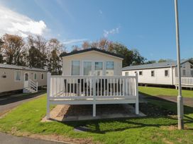 A mobile home with a deck and railing at 14 Pines in Cayton Bay