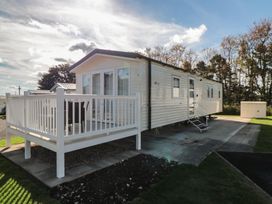 A static caravan with decking and steps at 14 Pines in Cayton Bay