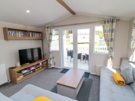 A living room with a television and a coffee table at 14 Pines in Cayton Bay