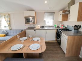 A kitchen with dining area and sofa at 14 Pines in Cayton Bay