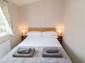 A bedroom with a bed and lamps at 14 Pines in Cayton Bay