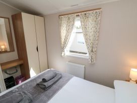 A bedroom with a bed and a dresser at 14 Pines in Cayton Bay