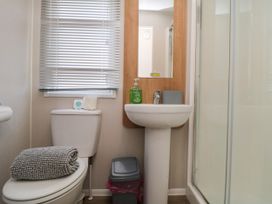 A bathroom featuring a toilet, sink, and shower at 14 Pines in Cayton Bay