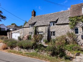 A stone house with a garage at Farthing Cottage in Corfe Castle