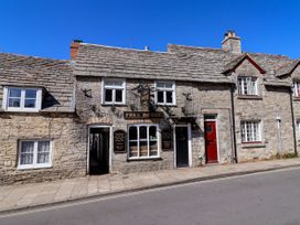 A building with a sign and multiple windows at Farthing Cottage in Corfe Castle