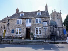 A building named The Old Curiosity Shop with a clock tower at Farthing Cottage Corfe Castle