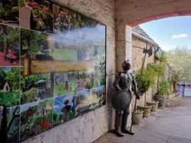 An outdoor area with a knight statue and display panels at Farthing Cottage in Corfe Castle