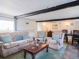 A living room with sofas and a coffee table at Farthing Cottage in Corfe Castle