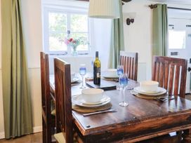 A dining room with a wooden table and chairs at Farthing Cottage in Corfe Castle