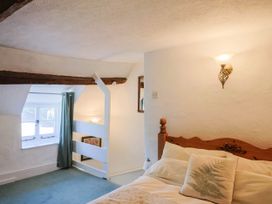 A bedroom with a bed and window at Farthing Cottage in Corfe Castle