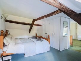 A bedroom with a bed and wardrobe at Farthing Cottage in Corfe Castle
