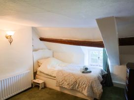 A bedroom with a bed and towel at Farthing Cottage in Corfe Castle
