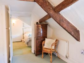 A bedroom with a dresser and chair at Farthing Cottage in Corfe Castle
