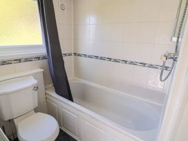 A bathroom with a bathtub and toilet at Farthing Cottage in Corfe Castle