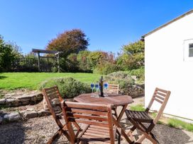 A garden with a table and chairs at Farthing Cottage in Corfe Castle