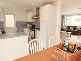 A kitchen with dining table and fridge at Cloudbreak in Wadebridge