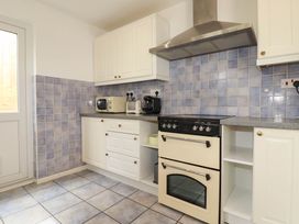 A kitchen with appliances and cabinets at Cloudbreak in Wadebridge
