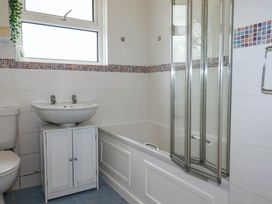 A bathroom with a sink, toilet, shower, and bathtub at Cloudbreak in Wadebridge