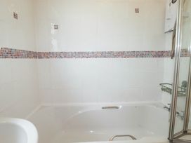 A bathroom with a bathtub and shower at Cloudbreak in Wadebridge