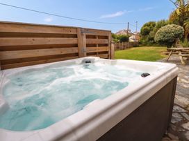 A hot tub in a garden area at Cloudbreak Wadebridge