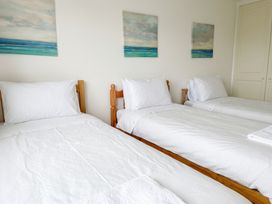 A bedroom with three beds and wall art at Cloudbreak in Wadebridge