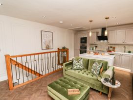 A living room with a green sofa and kitchen in 14 Brunswick Street Whitby