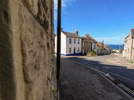 A street view with houses and sea at 57 High Street Portland