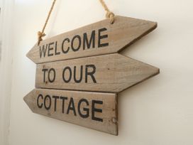 A wooden sign that reads welcome to our cottage at 57 High Street in Portland