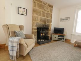 A living room with an armchair and fireplace at 57 High Street