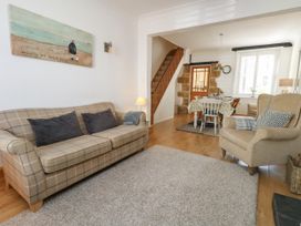A living room with a sofa and dining area at 57 High Street Portland