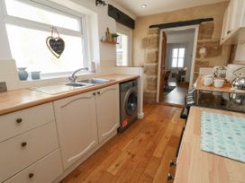 A kitchen with a sink and washing machine at 57 High Street Portland