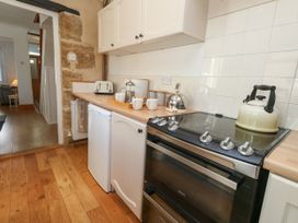 A kitchen with a stove, kettle, and sink at 57 High Street in Portland