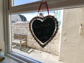 A window with a heart-shaped sign saying 'Hurrah for the sea' at 57 High Street Portland