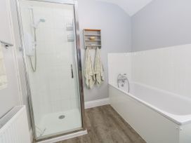 A bathroom featuring a shower and a bathtub at 57 High Street in Portland