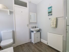 A bathroom with a toilet, sink, and towel at 57 High Street in Portland
