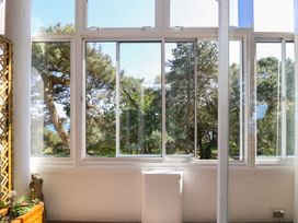 A sunroom with windows showing trees at The Pines in Bournemouth