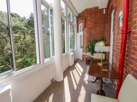 A conservatory with a table and lamp at The Pines in Bournemouth