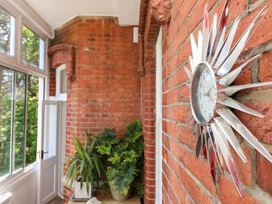 A hallway with a clock on the wall and a plant at The Pines in Bournemouth