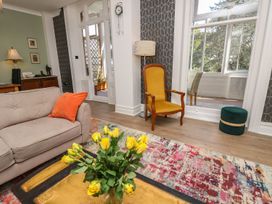 A living room with a sofa, chair, and floral arrangement at The Pines in Bournemouth