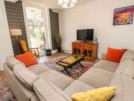 A living room with a sofa, coffee table, and television at The Pines in Bournemouth
