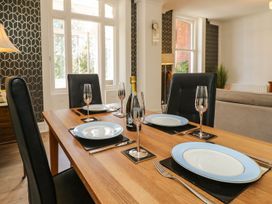 A dining room with a wooden table set for dinner at The Pines Bournemouth