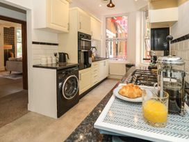 A kitchen with a washing machine and croissant on the counter at The Pines in Bournemouth