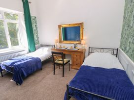 A bedroom with two beds and a table at The Pines in Bournemouth